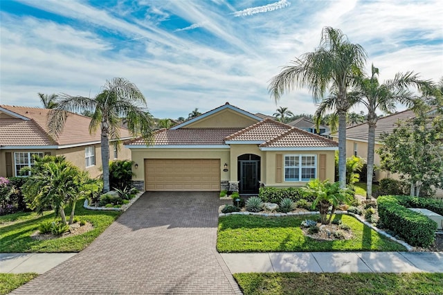 mediterranean / spanish-style home featuring a garage and a front yard