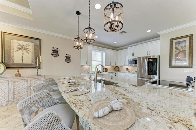 kitchen featuring a notable chandelier, a kitchen bar, white cabinetry, and stainless steel appliances