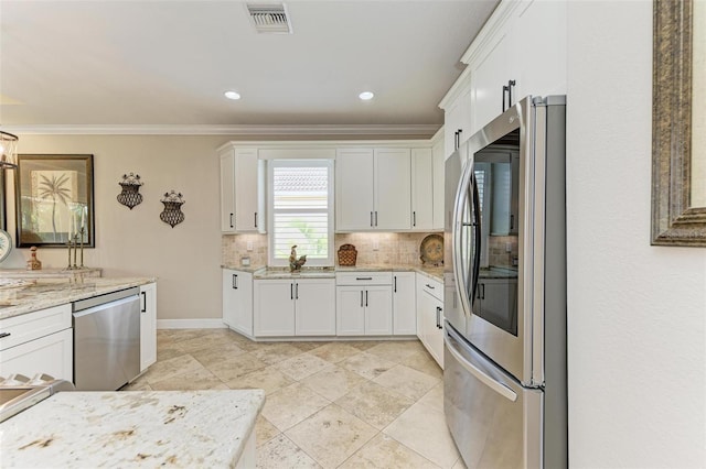 kitchen with white cabinets, light stone counters, and appliances with stainless steel finishes