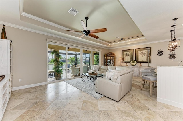 living room with a tray ceiling, track lighting, ceiling fan, and ornamental molding