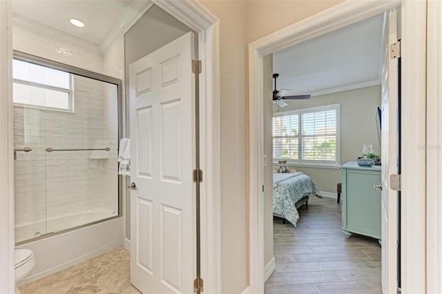 bathroom with ceiling fan, toilet, combined bath / shower with glass door, and ornamental molding