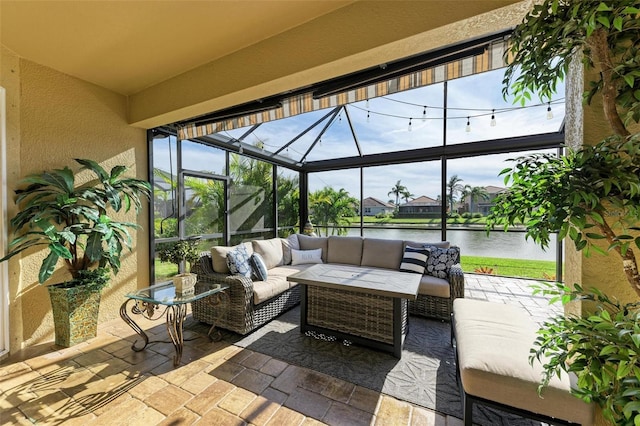 view of patio / terrace with a lanai, a water view, and an outdoor hangout area