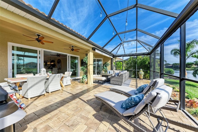 view of patio / terrace featuring a lanai, a water view, and an outdoor hangout area