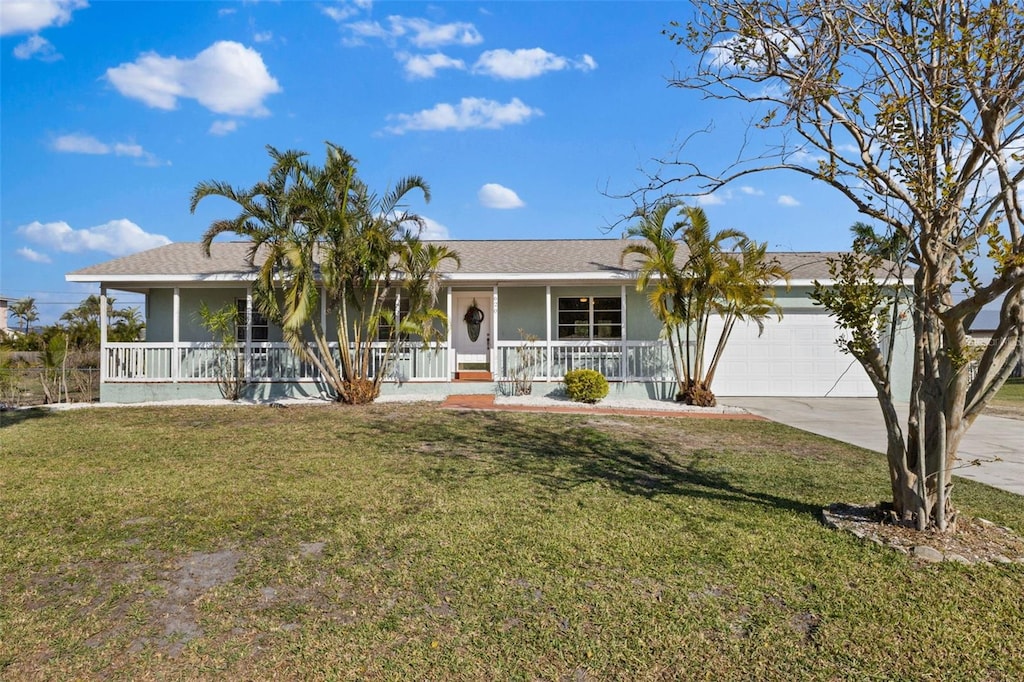 ranch-style house featuring a front yard, a garage, and covered porch