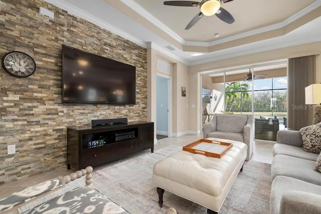 tiled living room featuring ornamental molding and a tray ceiling