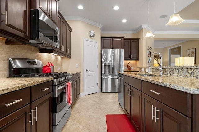 kitchen featuring tasteful backsplash, stainless steel appliances, crown molding, sink, and decorative light fixtures