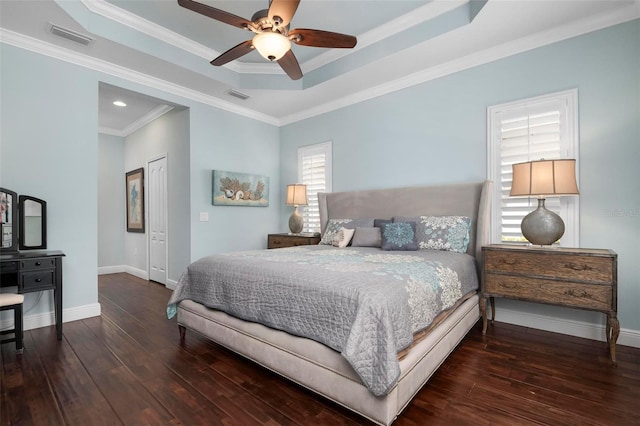 bedroom with a raised ceiling, ceiling fan, dark hardwood / wood-style floors, and ornamental molding