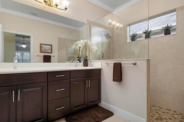 bathroom with ceiling fan, vanity, ornamental molding, and tiled shower