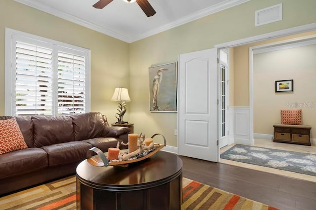 living room with hardwood / wood-style flooring, ceiling fan, and ornamental molding