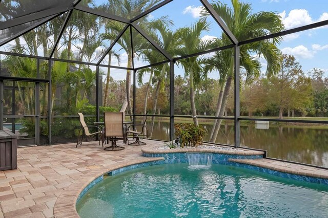 view of pool featuring pool water feature, a water view, a patio area, and a lanai