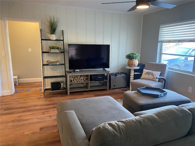 living room with hardwood / wood-style floors, ceiling fan, and ornamental molding