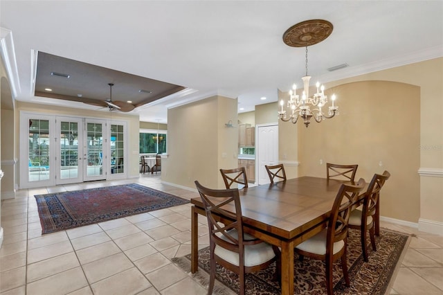 dining room featuring a raised ceiling, light tile patterned flooring, a healthy amount of sunlight, and ceiling fan with notable chandelier