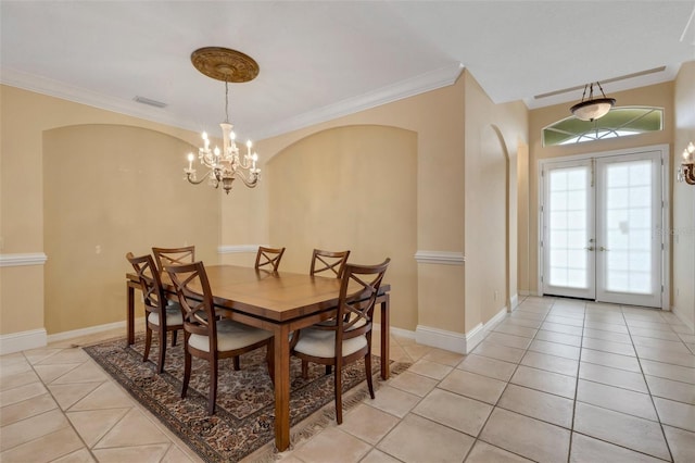 dining room featuring a chandelier, french doors, crown molding, and light tile patterned flooring