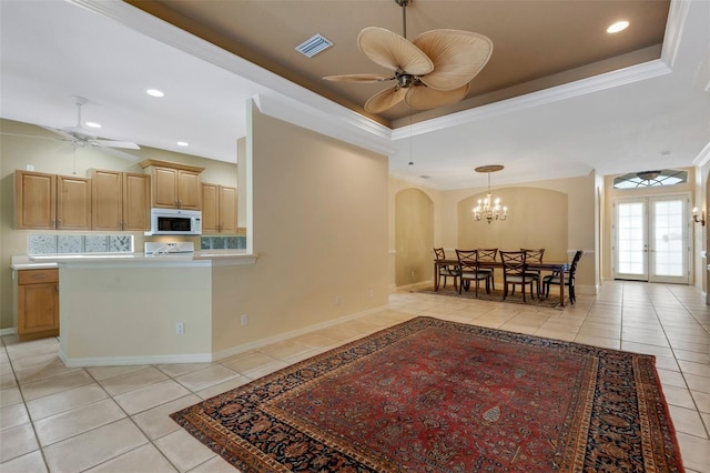 interior space featuring light tile patterned flooring, a tray ceiling, and french doors