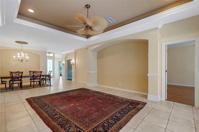 interior space featuring ceiling fan with notable chandelier, ornamental molding, and a tray ceiling