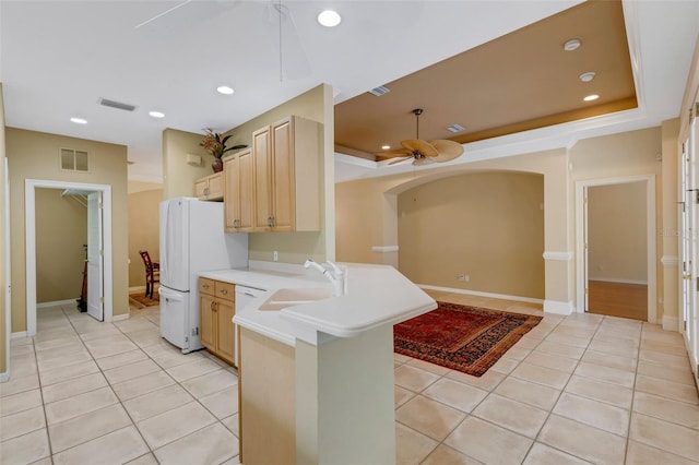 kitchen featuring kitchen peninsula, light tile patterned floors, light brown cabinetry, and sink