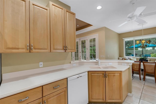 kitchen featuring white dishwasher, ceiling fan with notable chandelier, sink, light tile patterned floors, and kitchen peninsula