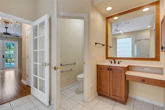 bathroom with toilet, tile patterned floors, ceiling fan, and a shower with shower door