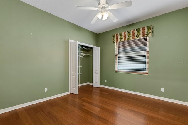 unfurnished bedroom featuring ceiling fan, a closet, and hardwood / wood-style flooring