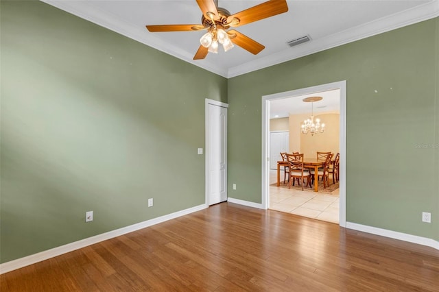 unfurnished room featuring ceiling fan with notable chandelier, light hardwood / wood-style floors, and ornamental molding