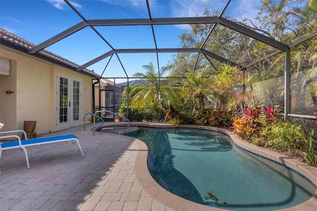 view of pool with glass enclosure, a patio, and french doors