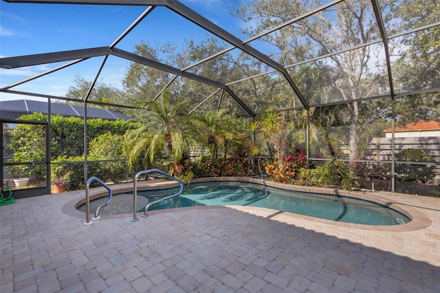 view of swimming pool featuring a patio area and a lanai