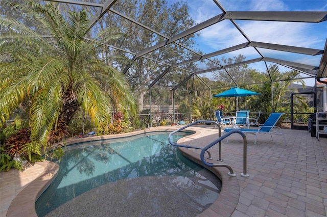 view of pool featuring glass enclosure and a patio