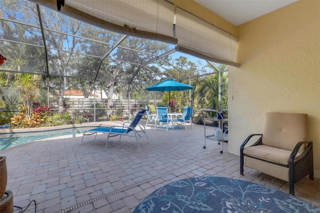 view of patio / terrace with a fenced in pool and glass enclosure