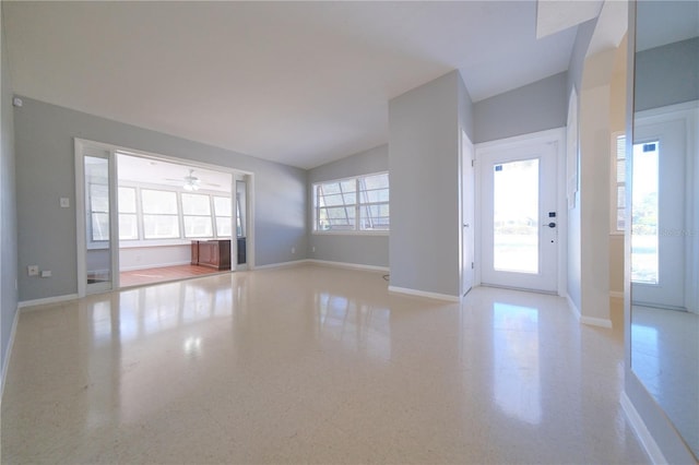 unfurnished living room with a wealth of natural light, ceiling fan, and lofted ceiling