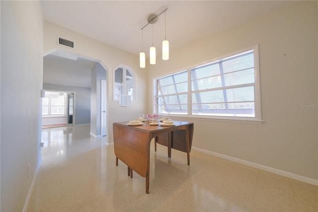 office featuring baseboards, visible vents, and arched walkways