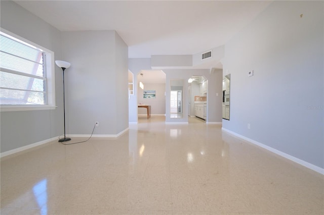 unfurnished living room with visible vents and baseboards