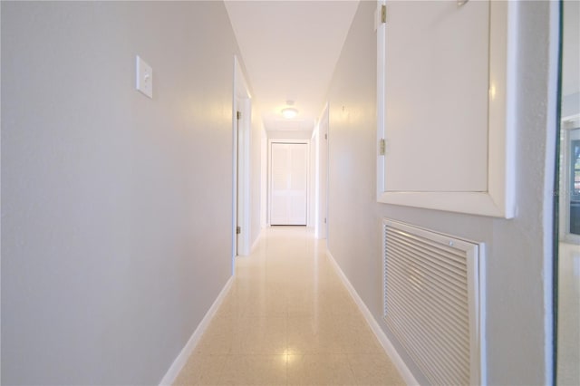 corridor with visible vents, baseboards, and light tile patterned flooring