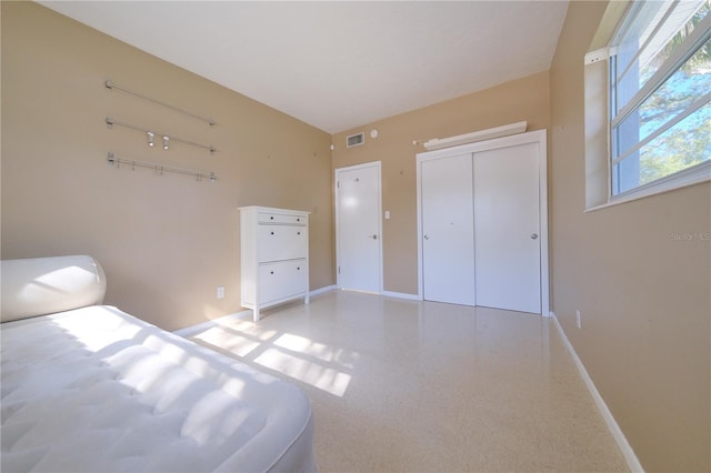 unfurnished bedroom featuring a closet, visible vents, and baseboards