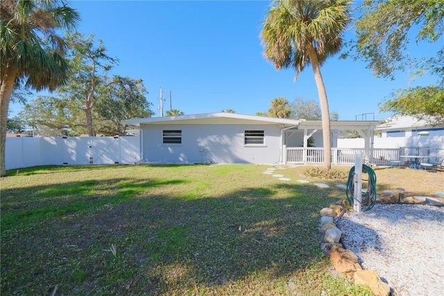 exterior space with stucco siding, a lawn, and fence