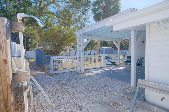 exterior space with a patio area, a fenced backyard, and a storage shed