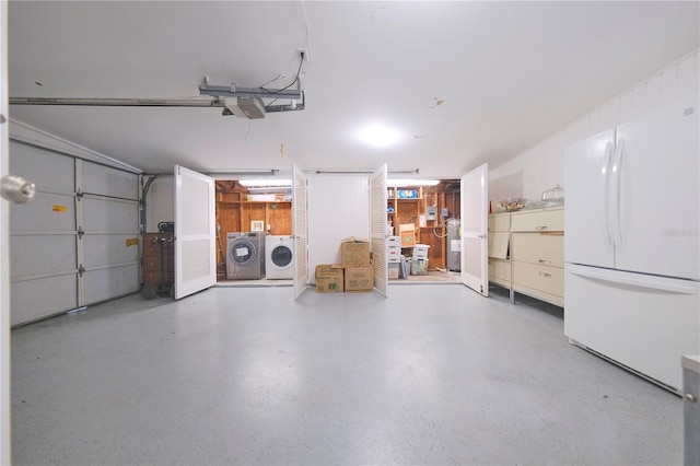 garage featuring a garage door opener, water heater, washer and clothes dryer, and freestanding refrigerator