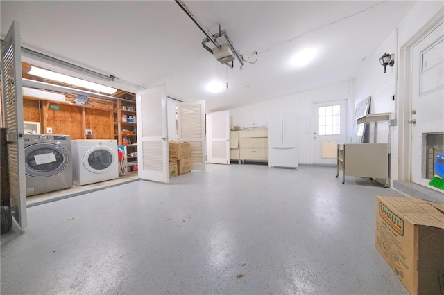 garage featuring washing machine and dryer and freestanding refrigerator