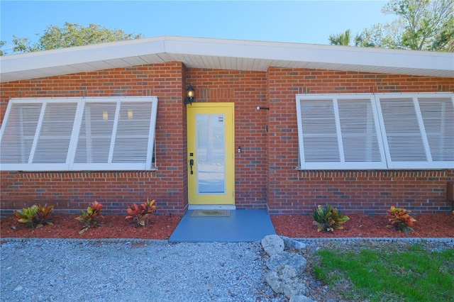 doorway to property featuring brick siding