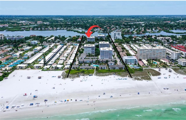 birds eye view of property with a water view and a beach view