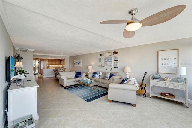 living room with ceiling fan, light tile patterned floors, and a textured ceiling