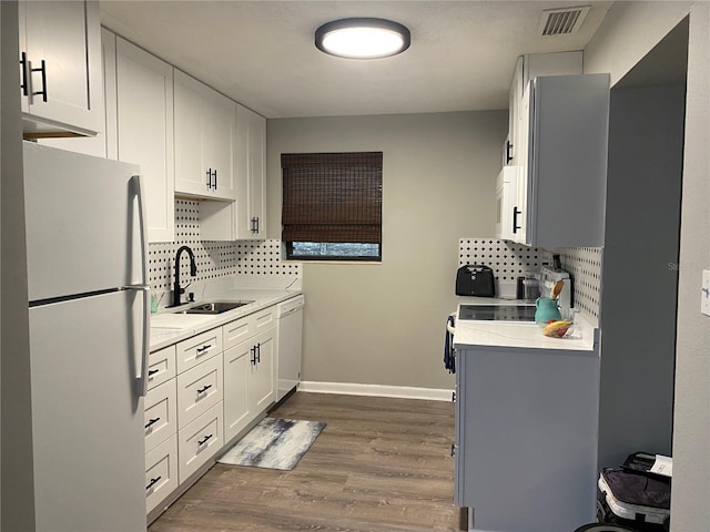 kitchen featuring white cabinets, white appliances, tasteful backsplash, and sink