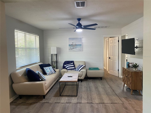 living room featuring hardwood / wood-style floors, a textured ceiling, and ceiling fan