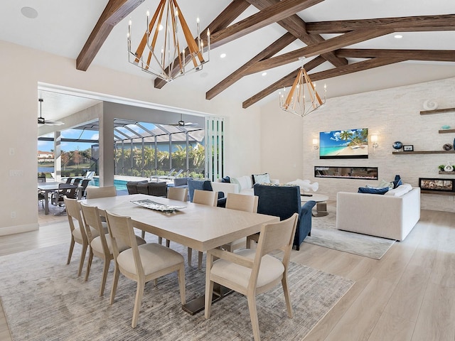 dining area featuring beam ceiling, ceiling fan with notable chandelier, light hardwood / wood-style floors, and high vaulted ceiling