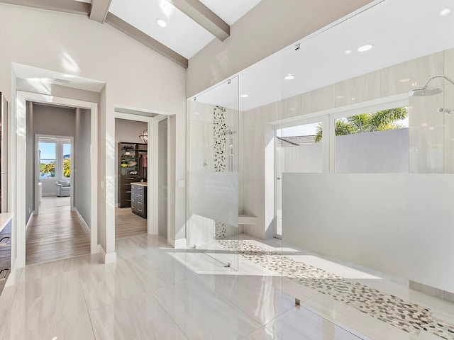 bathroom featuring a shower and lofted ceiling with beams