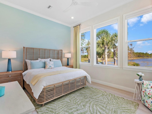 bedroom featuring ceiling fan, light hardwood / wood-style floors, crown molding, and multiple windows