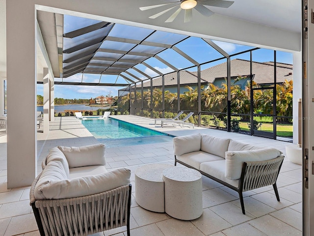 view of pool featuring outdoor lounge area, ceiling fan, a patio area, and a lanai