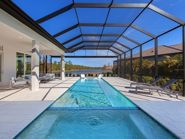 view of pool with glass enclosure and a patio