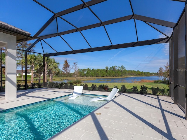 view of pool featuring a patio, a water view, and glass enclosure