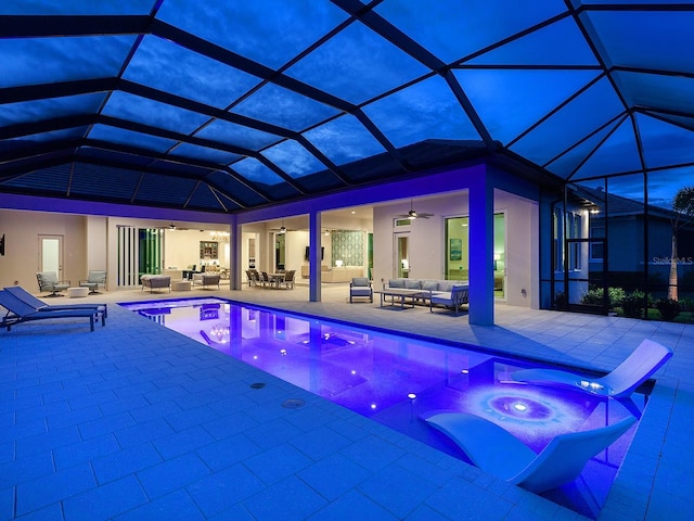 view of pool with an outdoor living space, a hot tub, ceiling fan, and a lanai