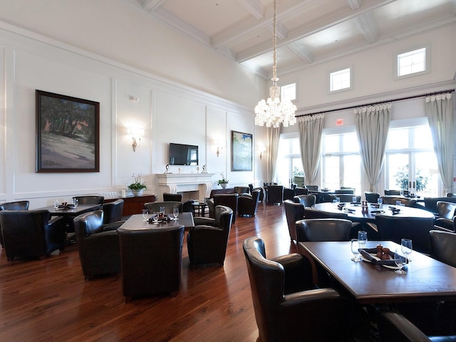 dining space featuring beam ceiling, dark hardwood / wood-style flooring, a chandelier, and coffered ceiling